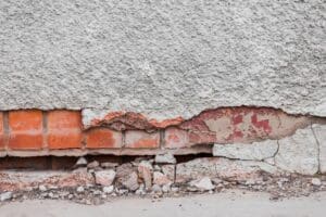 The foundation of a building collapsing with cracks due to heaving and foundation settlement